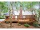 Backyard featuring a raised wooden deck, brick exterior, and mature tree coverage at 721 Summerwood Dr, Rock Hill, SC 29732