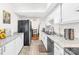 Galley kitchen features white cabinets, granite countertops, stainless steel dishwasher, and dining area access at 7407 Mystic Ln, Charlotte, NC 28227