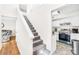 Bright staircase featuring carpeted stairs, white walls, and direct access to a modern kitchen space at 7407 Mystic Ln, Charlotte, NC 28227