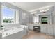 Bright bathroom features a large soaking tub, double vanity, and abundant natural light from a large window at 8800 Darcy Hopkins Dr, Charlotte, NC 28277