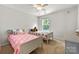 Shared bedroom with two twin beds, carpet, and a view of the greenery outside the window at 8800 Darcy Hopkins Dr, Charlotte, NC 28277