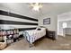 bedroom with black and white striped accent wall and a built-in bookcase at 8800 Darcy Hopkins Dr, Charlotte, NC 28277