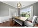 Bright dining room with a modern chandelier, large window, and wainscoting at 8800 Darcy Hopkins Dr, Charlotte, NC 28277
