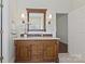 Bathroom with wood vanity, quartz countertops, and decorative sconces at 1000 Millbank Dr, Matthews, NC 28104