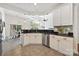 Open kitchen with stainless steel appliances, white cabinets, dark countertops, and eat-in breakfast bar at 1000 Millbank Dr, Matthews, NC 28104