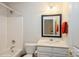Bright bathroom features a shower-tub combo, vanity with mirror, and neutral finishes at 10314 Threatt Woods Dr, Charlotte, NC 28277