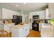 Well-lit kitchen with white cabinets, tile backsplash, and stainless steel appliances at 10314 Threatt Woods Dr, Charlotte, NC 28277