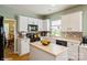 Bright kitchen with white cabinets, an island, stainless appliances, and a tile backsplash at 10314 Threatt Woods Dr, Charlotte, NC 28277