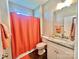 Bright bathroom features an orange shower curtain, decorative mirror, and tiled floors at 1050 Coppergate Dr, Salisbury, NC 28147