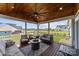 Inviting covered patio boasts wood ceiling, ceiling fan, fire pit, and comfortable seating perfect for relaxation and entertaining at 1050 Coppergate Dr, Salisbury, NC 28147