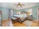 A well-lit main bedroom with a ceiling fan, wooden floors, and a king-sized bed at 106 S Oakwood Dr, Kings Mountain, NC 28086