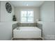 Bright bathroom features a soaking tub with tile surround and a large window at 10707 Charmont Pl, Huntersville, NC 28078