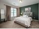 Relaxing bedroom with a green accent wall, soft carpet, and bright windows at 10707 Charmont Pl, Huntersville, NC 28078