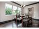 Bright dining room featuring a modern chandelier, dark trim, large windows, and wooden furniture at 10707 Charmont Pl, Huntersville, NC 28078