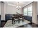 Inviting dining room with dark wood floors, wainscoting, and a modern chandelier at 10707 Charmont Pl, Huntersville, NC 28078