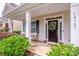 Charming front entrance with a decorative wreath, rocking chairs, and manicured bushes at 10707 Charmont Pl, Huntersville, NC 28078
