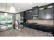 A modern kitchen featuring granite countertops, gray cabinets, stainless steel appliances, and view into breakfast nook at 10707 Charmont Pl, Huntersville, NC 28078