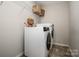 Laundry room featuring modern washer and dryer with shelving for storage at 10707 Charmont Pl, Huntersville, NC 28078