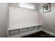 Bright mud room with built-in bench, hooks, storage cubbies, and dark wood flooring at 10707 Charmont Pl, Huntersville, NC 28078