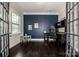 Bright office featuring a large window, french doors, and dark wood flooring at 10707 Charmont Pl, Huntersville, NC 28078