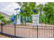 Community playground with a slide, a climbing wall, and a swing set surrounded by mature trees at 10707 Charmont Pl, Huntersville, NC 28078