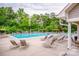 Community pool with lounge chairs, mature trees, and lush landscaping creating a relaxing escape at 10707 Charmont Pl, Huntersville, NC 28078