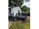 Rear deck features black stained wood and a walk down to a backyard with natural landscaping at 1104 Linwood Rd, Gastonia, NC 28052