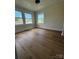 This bedroom features hardwood floors, base moulding, neutral paint, and three windows at 1104 Linwood Rd, Gastonia, NC 28052