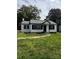 Charming home features a white exterior, black trim, a gray roof and a well-maintained lawn at 1104 Linwood Rd, Gastonia, NC 28052
