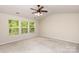 Bedroom with neutral carpet, and three windows providing natural light with views of trees outside at 11220 Cypress View Dr, Charlotte, NC 28262