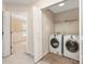 Laundry room with neutral paint and tile floors, including a washer and dryer and access to a bedroom at 11220 Cypress View Dr, Charlotte, NC 28262