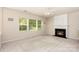 Bright living room with fireplace, ceiling fan, and large windows overlooking the greenery at 11220 Cypress View Dr, Charlotte, NC 28262