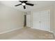 A carpeted bedroom featuring double closets, a ceiling fan, and access to other rooms at 1139 Hampton Gardens Ln, Charlotte, NC 28209