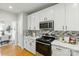 The open kitchen features stainless steel appliances, granite counters, and white cabinets at 1139 Hampton Gardens Ln, Charlotte, NC 28209