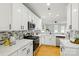 Modern kitchen with white cabinets, stainless steel appliances, and a tile backsplash at 1139 Hampton Gardens Ln, Charlotte, NC 28209