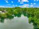 Scenic aerial view of a pond surrounded by lush greenery and beautiful homes at 11732 Borchetta Dr, Charlotte, NC 28277