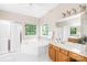 Bright bathroom featuring double windows above large tub and glass shower door at 11732 Borchetta Dr, Charlotte, NC 28277