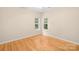 Bedroom with hardwood floors, white trim, and two windows offering natural light at 11732 Borchetta Dr, Charlotte, NC 28277
