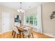 Cozy dining room with a wooden table, chandelier, and a large window overlooking the lush yard at 11732 Borchetta Dr, Charlotte, NC 28277