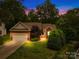 Charming brick home featuring a well-manicured lawn and an attached two-car garage at dusk at 11732 Borchetta Dr, Charlotte, NC 28277