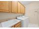 Laundry room with white appliances, a large sink, and ample overhead cabinet space at 11732 Borchetta Dr, Charlotte, NC 28277