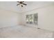 Spacious bedroom featuring a tray ceiling and a large window, offering ample natural light at 12004 Willingdon Rd, Huntersville, NC 28078