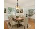 Elegant dining room with a wood table, six chairs, chandelier, and views to the front yard at 12004 Willingdon Rd, Huntersville, NC 28078