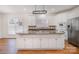 Bright kitchen with white cabinets, stainless steel appliances, a center island, and a stylish hanging pot rack at 12004 Willingdon Rd, Huntersville, NC 28078