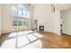 Sun-drenched living room boasting hardwood floors, a cozy fireplace, and expansive windows at 12004 Willingdon Rd, Huntersville, NC 28078