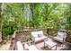 Outdoor deck space featuring lounge furniture with beautiful green trees surrounding the area at 142 Gray Barn Dr, Troutman, NC 28166