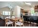 Open-concept dining area connecting to the kitchen and living room, featuring a table with seating and island with barstools at 142 Gray Barn Dr, Troutman, NC 28166
