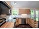 Modern kitchen showcasing countertops, stainless steel appliances, wood cabinets, and natural light from windows at 142 Gray Barn Dr, Troutman, NC 28166