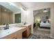 Bright main bathroom featuring double sinks, wood cabinets, and access to the main bedroom at 142 Gray Barn Dr, Troutman, NC 28166