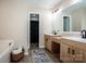 Bright bathroom featuring double sinks, wood cabinets, and tile floors at 142 Gray Barn Dr, Troutman, NC 28166